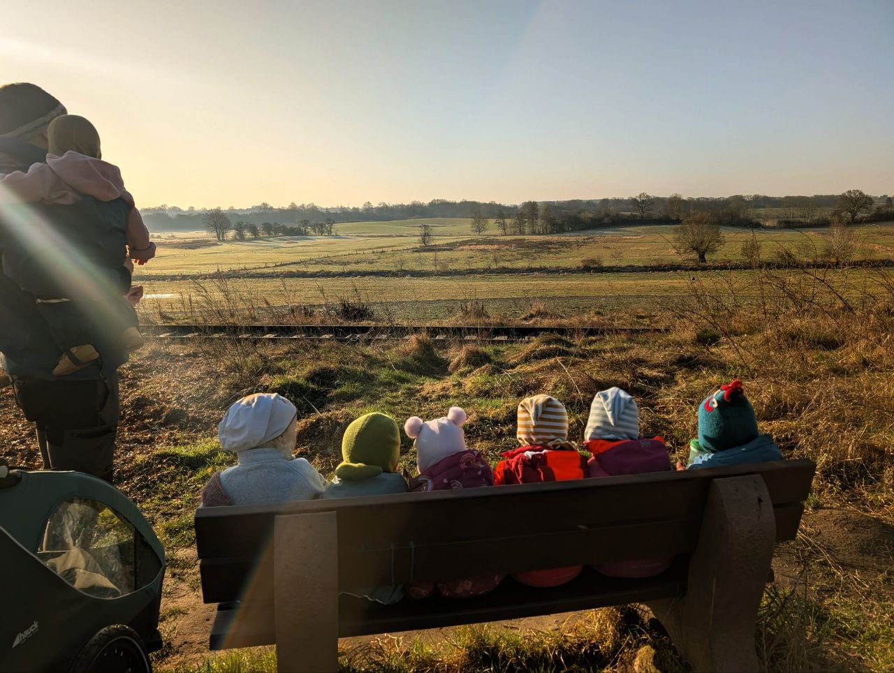 Kinder sitzen auf einer Bank vor weiter Landschaft